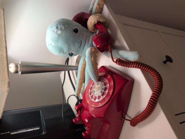 Stuffed octopus holding the receiver in one tentacle and dialing the rotor in the other